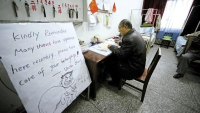 張大爺在門衛(wèi)室里工作，旁邊是紅爆網(wǎng)絡的溫馨提示牌記者