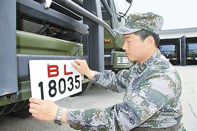 駐京某部上士高振超正在認(rèn)真更換新式軍車號牌。　　　本報(bào)記者　尹　航攝
