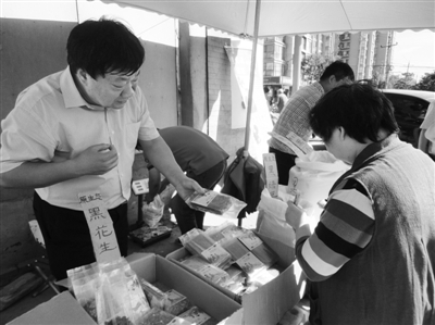 昨日，河南企業家劉春喜在京“練攤”，為顧客挑選綠豆。新京報記者 張玉學 攝