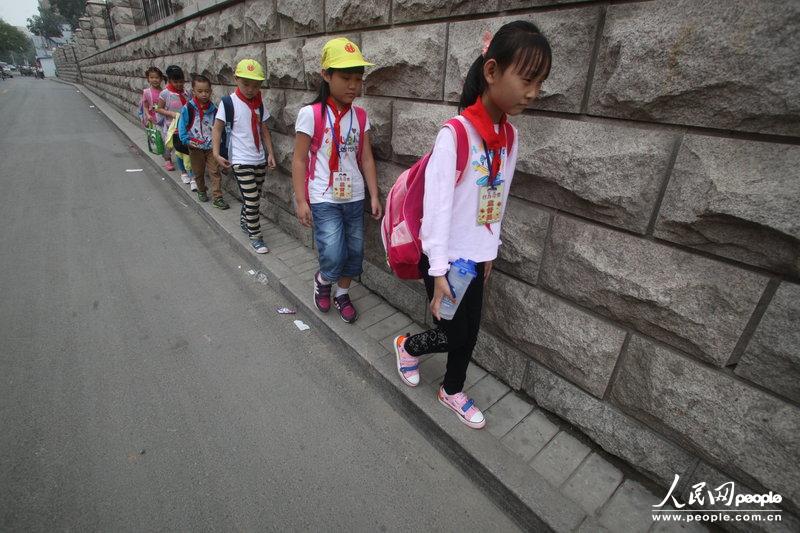 2013年09月11日，濟南運署街上，小學生走史上“最窄人行道”上學。圖片來源：CFP