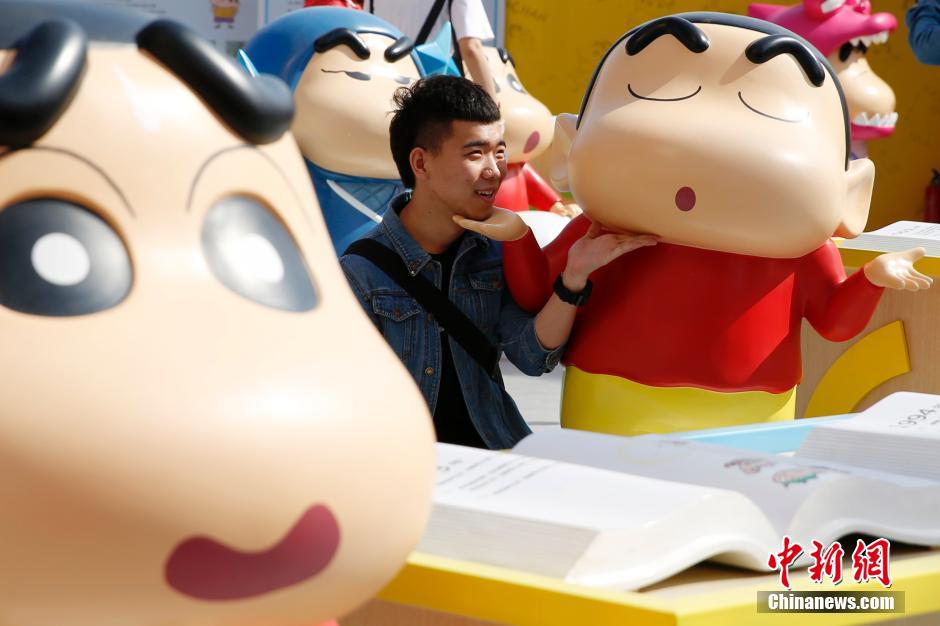 4月22日，游客與蠟筆小新合影?！跋灩P小新25周年紀念特展”日前在北京開展，吸引了不少市民游客。
