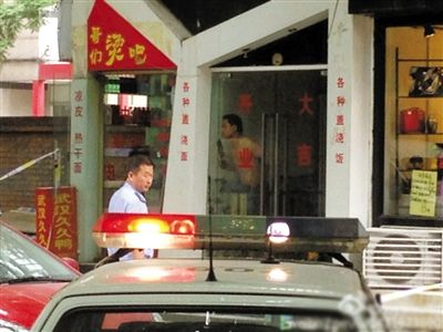 闖入面館的持刀男子與趕來的民警隔著玻璃門對峙，后店內(nèi)一名女童被其劫持。網(wǎng)友供圖