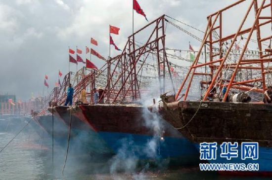 2013年8月1日 南海開漁日 臨高迎新港 8月1日，海南省臨高縣漁民在船上鳴放鞭炮慶祝武蓮港開港。