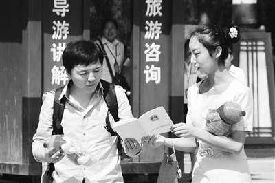 9月13日，西安臨潼華清池景區(qū)服務人員向游客介紹《旅游法》。