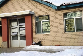 伊春市帶嶺區一排破舊的平房，房間窗戶上貼滿了“我告饒了”的字樣。