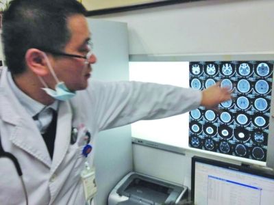 醫生在查看男孩的腦部CT片。薛馬義 攝
