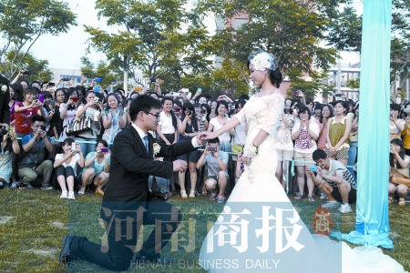 在學(xué)校操場(chǎng)的草坪上，兩名畢業(yè)生舉行婚禮，有同學(xué)感動(dòng)地抹起眼淚