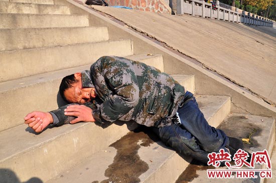 這名男子的衣服以及褲子全濕透了，水從衣褲里流出來，嘴里散發(fā)著濃烈的酒氣。