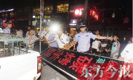 7月8日晚，鄭州市商城路一家占道經營的攤販招牌被執法隊員“登記保存”