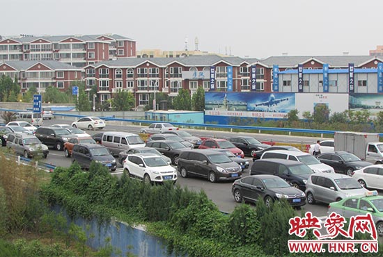 記者看到鄭州機場收費站口車輛排隊，與此形成鮮明對比的是，路的對面（另一半幅）卻車輛較少，通行順暢。
