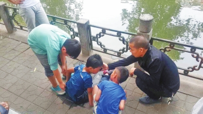 男孩被救出后，圍觀群眾幫他控水換衣服。