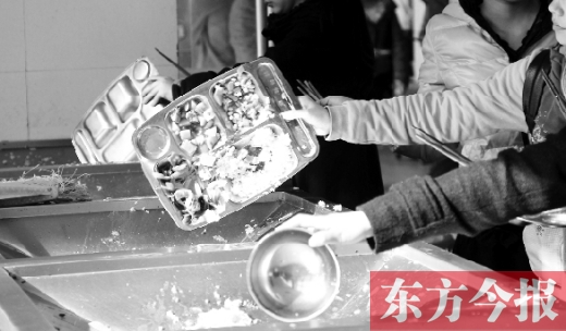 11月27日，河南中醫(yī)學(xué)院餐廳，一名同學(xué)將餐盤內(nèi)沒吃完的食物倒入餐具回收車內(nèi)