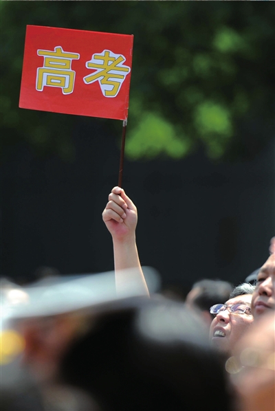 6月7日，在東直門考點(diǎn)外，一名家長(zhǎng)手舉高考的小旗子迎接孩子。資料圖片本報(bào)記者王苡萱攝