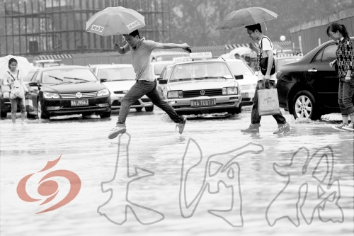 鄭州經三路與北環交叉口處，積水較深，行人們不得不“練輕功”。 記者 白周峰 攝影