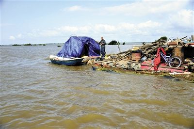 15日，因黑龍江水位上漲，一位轉移家中物資被困屋頂?shù)睦先讼蛎窬笾Ｐ氯A社發(fā)