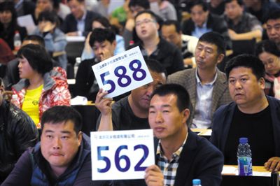昨日，拍賣現場競拍者舉牌競拍。新京報記者