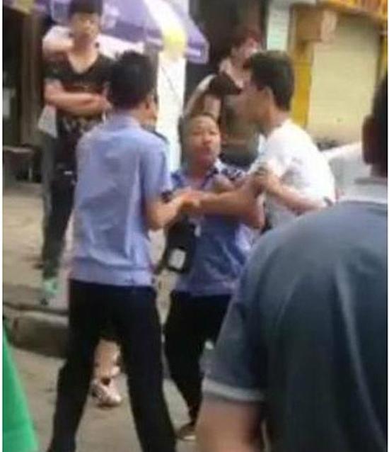 付某（右）與城管執法人員廝打在一起。