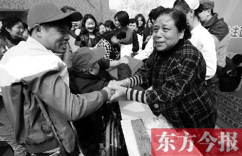 昨日，鄭大四附院的大樓前，“面人鄭”鄭玉芬（右）向前來(lái)捐款的殘疾人表示感謝