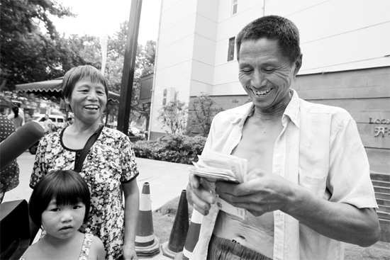 昨日，鄭州市明達(dá)路與豐慶路交叉口西300米路南，來自中牟的瓜農(nóng)拿到西瓜款，笑開顏東方今報(bào)記者袁曉強(qiáng)