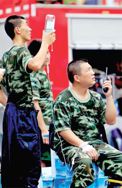 火場外，被消防戰士稱為“李大隊”的救援人員掛著吊瓶現場指揮