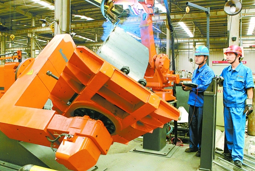 圖為龍工集團(tuán)中原公司的職工正在操作機(jī)器人焊接裝載機(jī)。