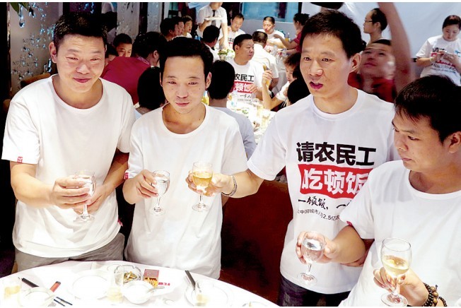 活動發起人張楠（右二）給農民工敬酒。