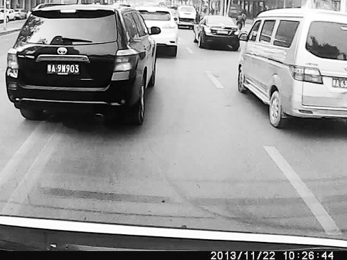 這輛黑色車輛不避讓執行緊急任務的救護車，并壓著雙黃線變更車道。唐韜/圖