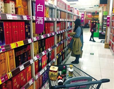 顧客在商場(chǎng)的高檔白酒貨架前駐足挑選。春節(jié)臨近，受“禁令”影響，以高檔白酒為代表的節(jié)日禮品市場(chǎng)面臨考驗(yàn)。記者 王遠(yuǎn)征 攝