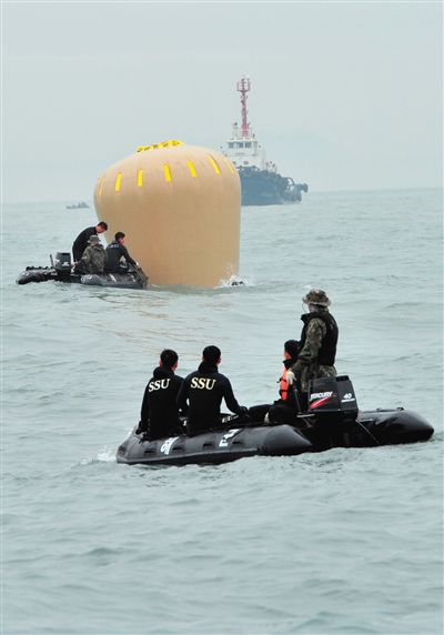 18日，搜救人員準備將氣囊捆綁到沉沒客輪上。