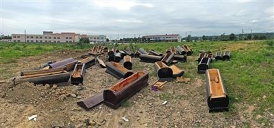40多副棺木被砸壞后，扔在荒地上。