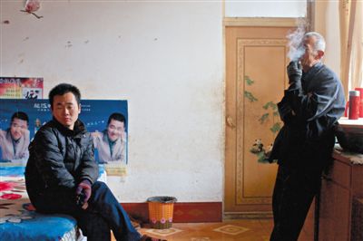 父親抽煙，兒子不語。逃跑的越南新娘，給袁迎賓父子帶來的是失落。新京報記者