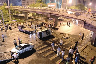 路虎沖下國(guó)貿(mào)橋砸中一輛起亞轎車(chē)，橋上厚達(dá)幾十厘米的水泥護(hù)欄被撞斷，碎石四處散落，數(shù)十群眾在現(xiàn)場(chǎng)圍觀。