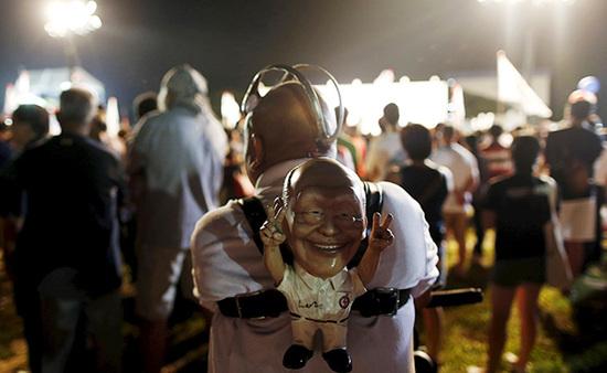 9月4日，新加坡，執(zhí)政黨的一場(chǎng)集會(huì)上，一名支持者背著一個(gè)李光耀的人偶。