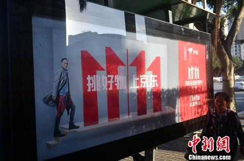 資料圖：11月1日，福州民眾從雙十一廣告牌前經(jīng)過(guò)。中新社記者 呂明 攝