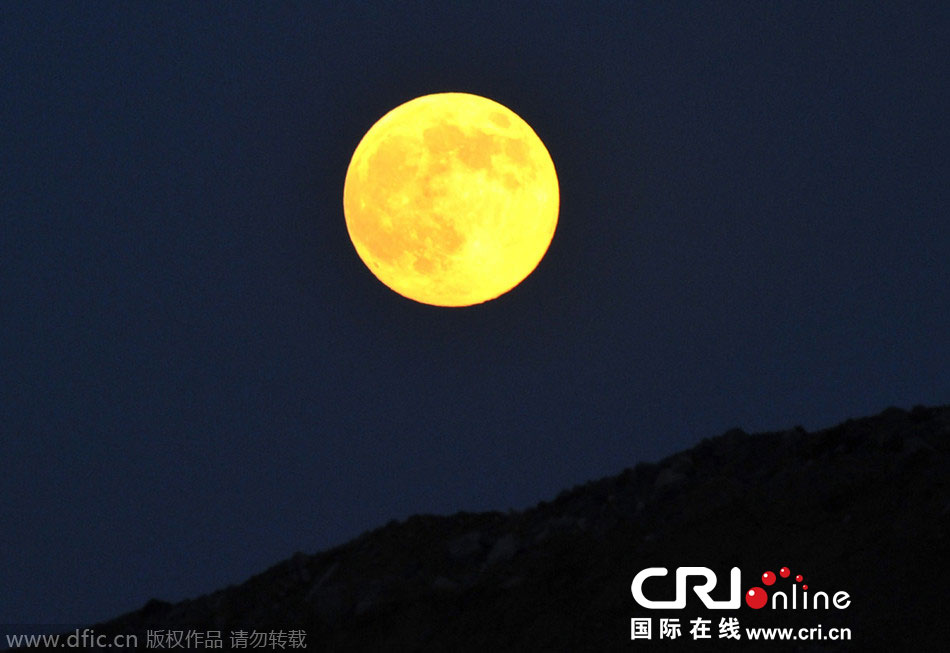 8月10日晚，一輪金燦燦的大月亮在遼寧省大連市東方升起。圖片來源：劉德斌/東方IC