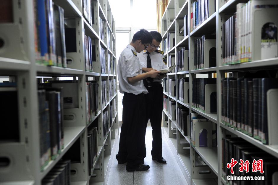 5月8日，武漢輕工大學保安吳濤與江力在圖書館交流學習。中新社發(fā) 張暢 攝